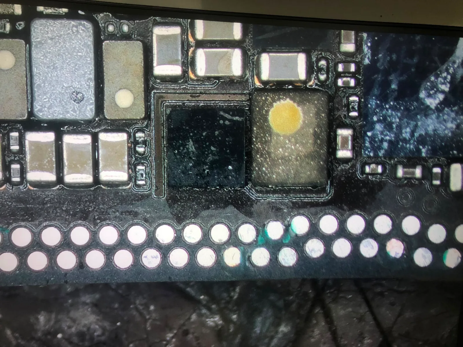 iPhone 11 anakartında onarılan kopuk yolların yakın görüntüsü